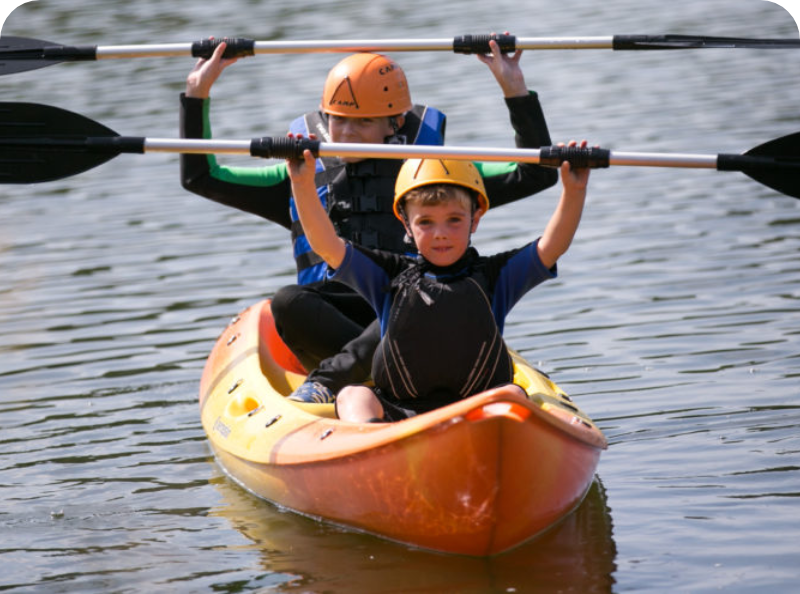 a child and a man in a kayak