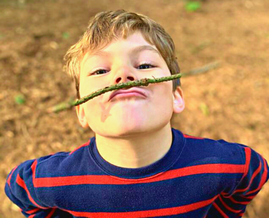 a boy holding a stick between his mouth and nose
