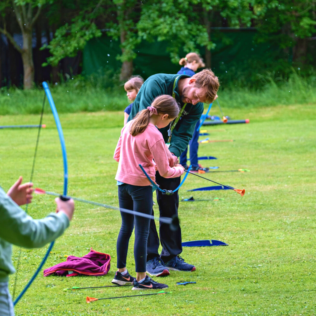 kids learning how to shoot through bow and arrow