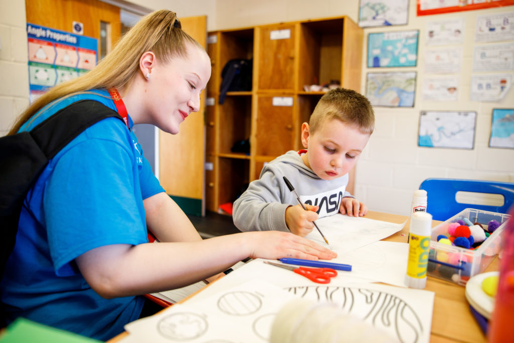 a woman and a kid drawing something