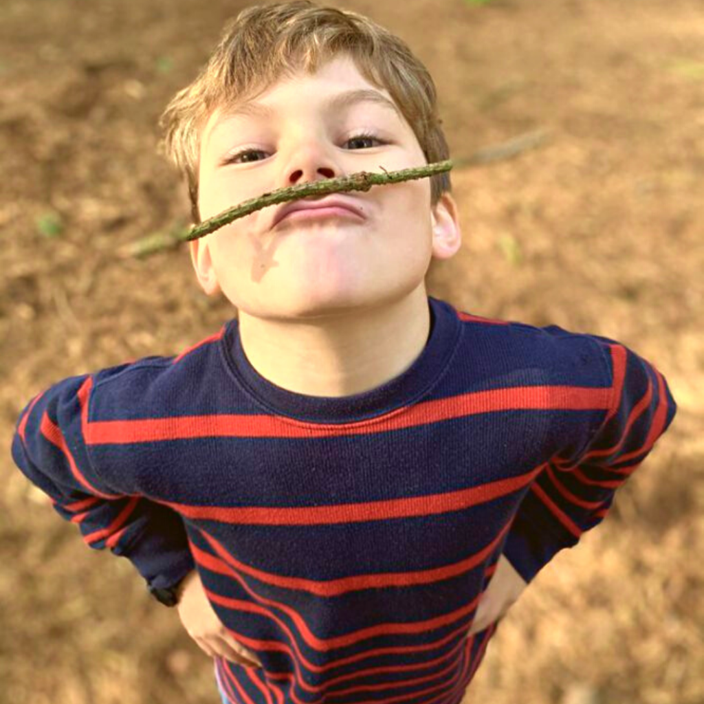 a boy holding a stick between his mouth and nose