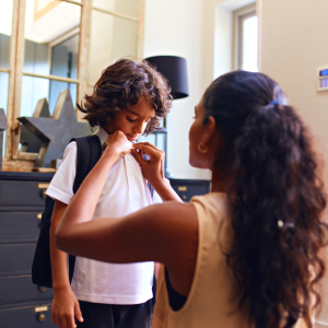 Mother getting her son ready for school.