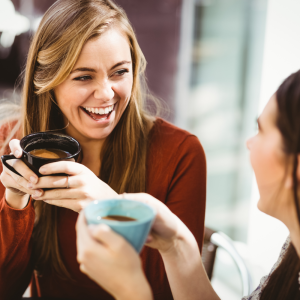 friends laughing and having fun while drink a cup of coffee