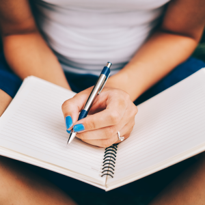 writing positive thinking in a notebook