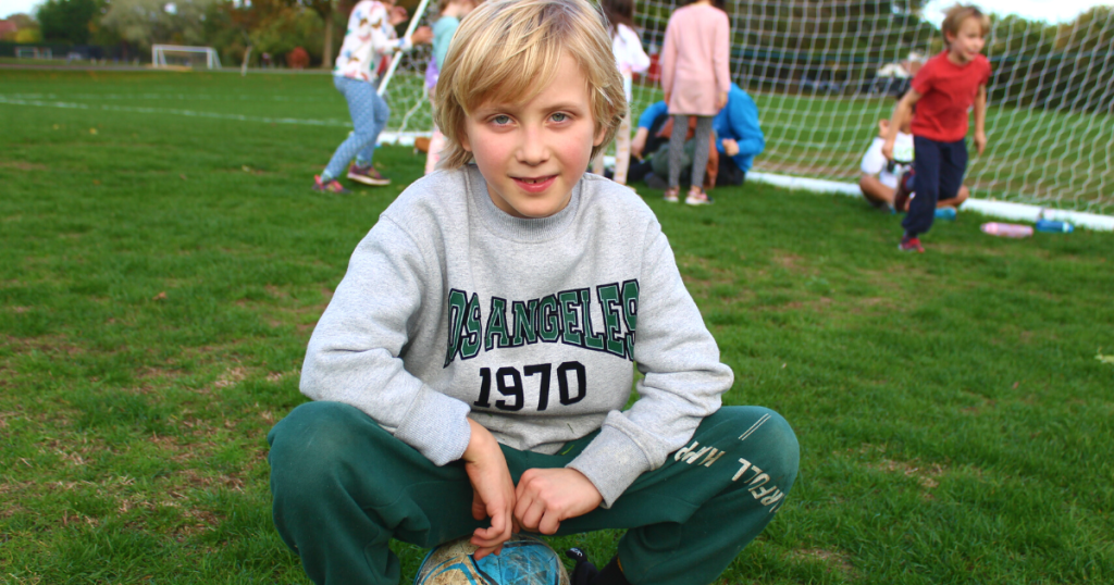 a kid sitting down in the grass